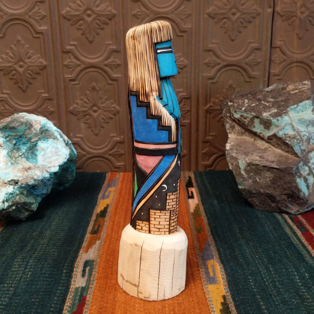 Shalako kachina featuring a carved blue face and starry nights in a pueblo motifs.