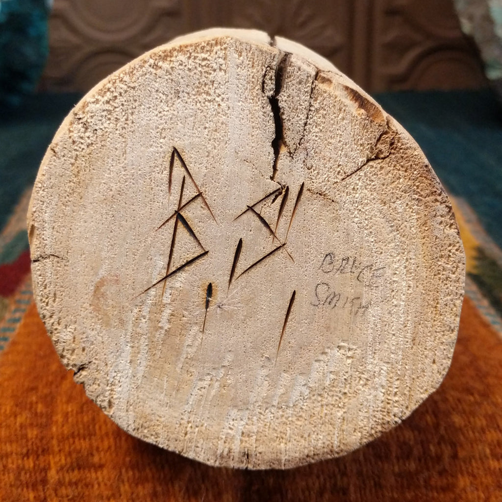 The artisan's signature is found at the base of the piece.