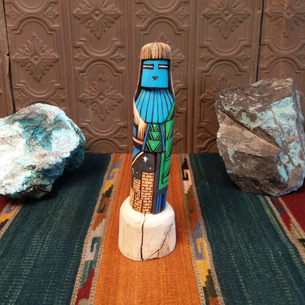 Shalako kachina featuring a carved blue face and starry nights in a pueblo motifs.