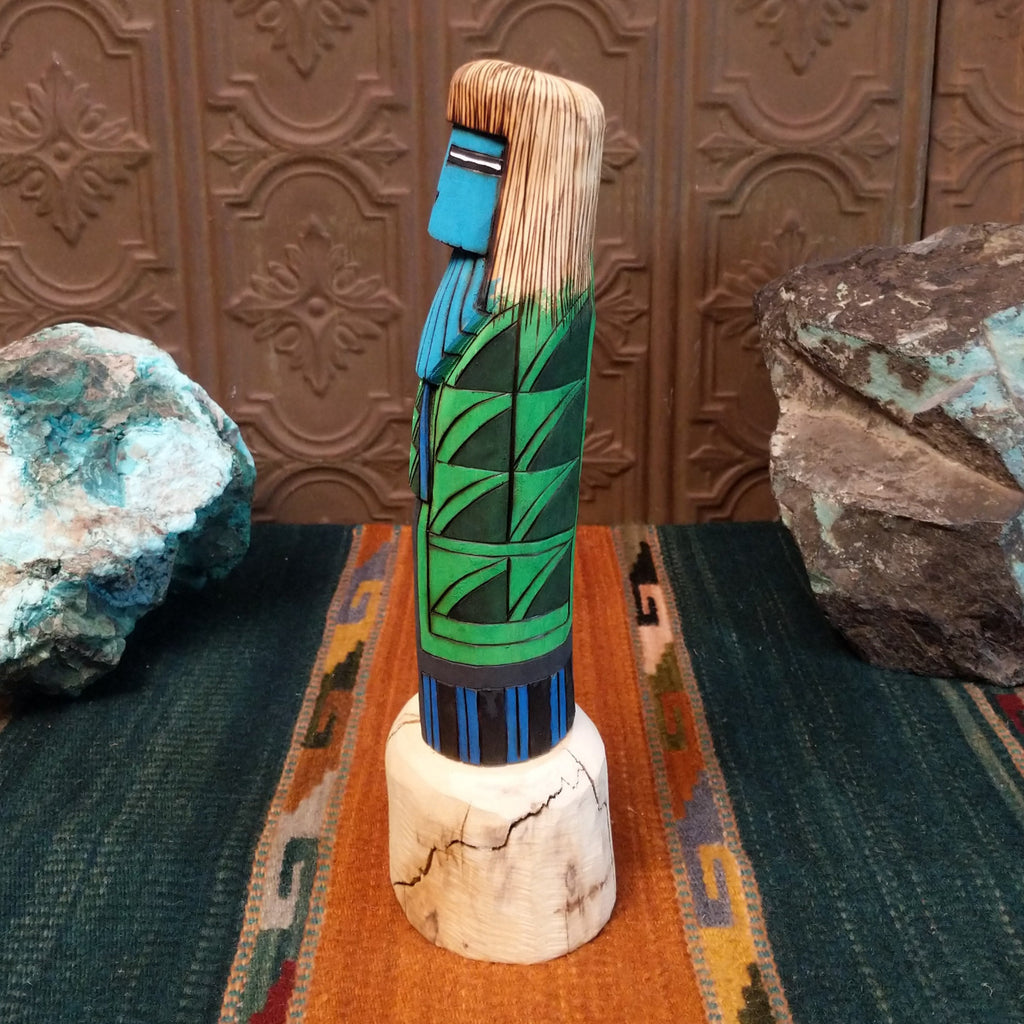 Shalako kachina featuring a carved blue face and starry nights in a pueblo motifs.