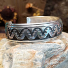 Sterling silver overlay cuff bracelet with repeating geometric motifs and oxidized detailing.