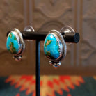 Sterling silver earrings with Sonoran Gold turquoise set in notched bezels, framed by dotted accents.