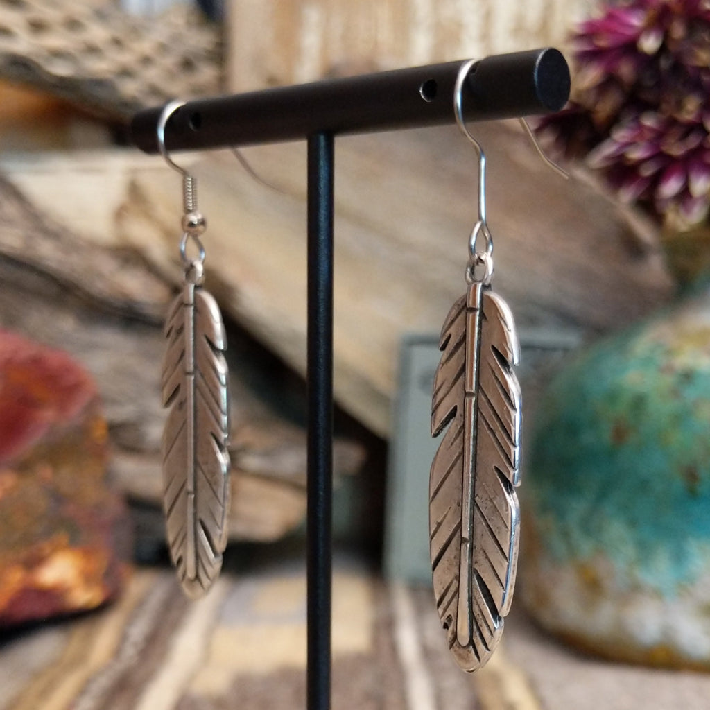 A pair of feather-shaped earrings.