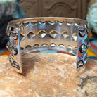 Wide silver cuff by Emerson Bill with raised diamond studs, crescent borders, and geometric stampwork.