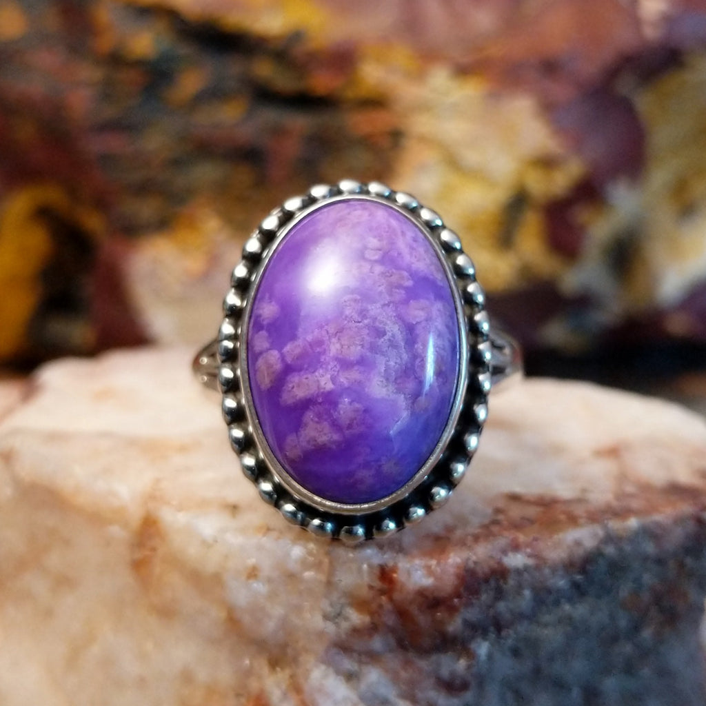 Sugilite framed by dotted accents, raised on the thin, sterling silver band.