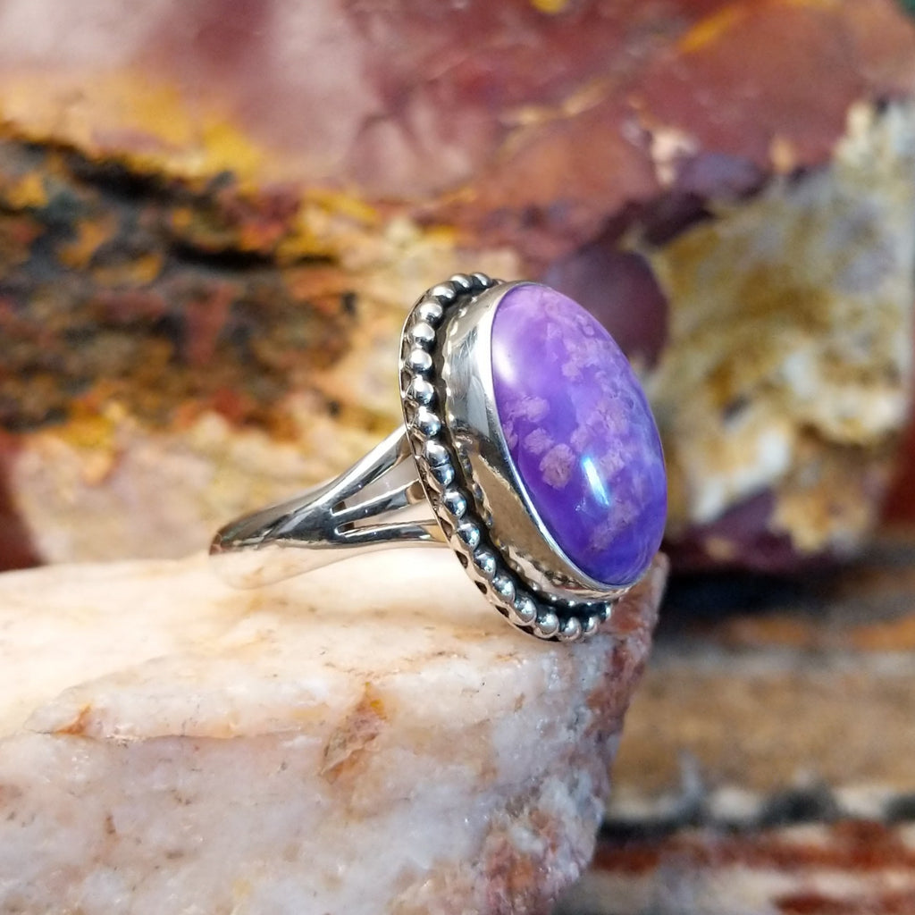 Sugilite framed by dotted accents, raised on the thin, sterling silver band.