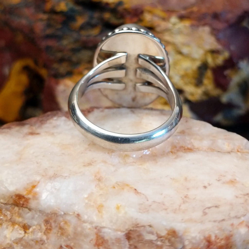 Sugilite framed by dotted accents, raised on the thin, sterling silver band.