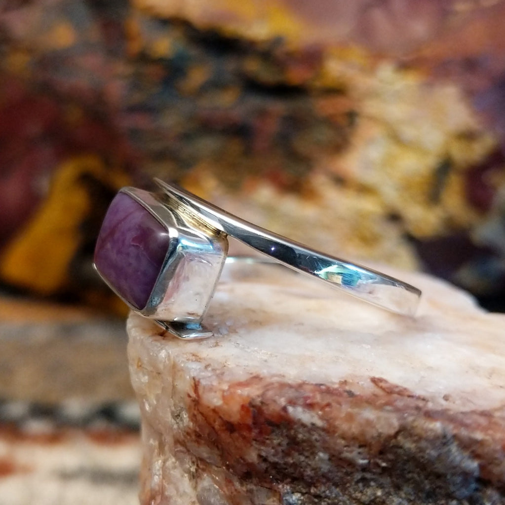 Sterling silver ring with a spiral band and sugilite stone set in the bezel.