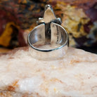 Triangular sugilite stone set within a sterling silver ring.