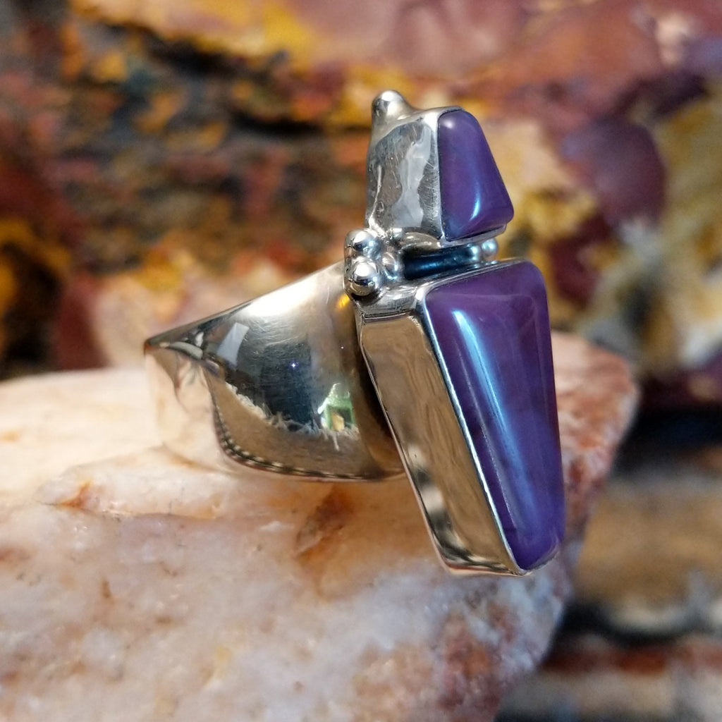 Triangular sugilite stone set within a sterling silver ring.