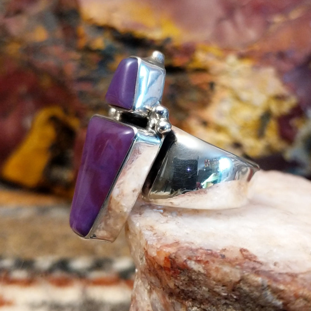 Triangular sugilite stone set within a sterling silver ring.