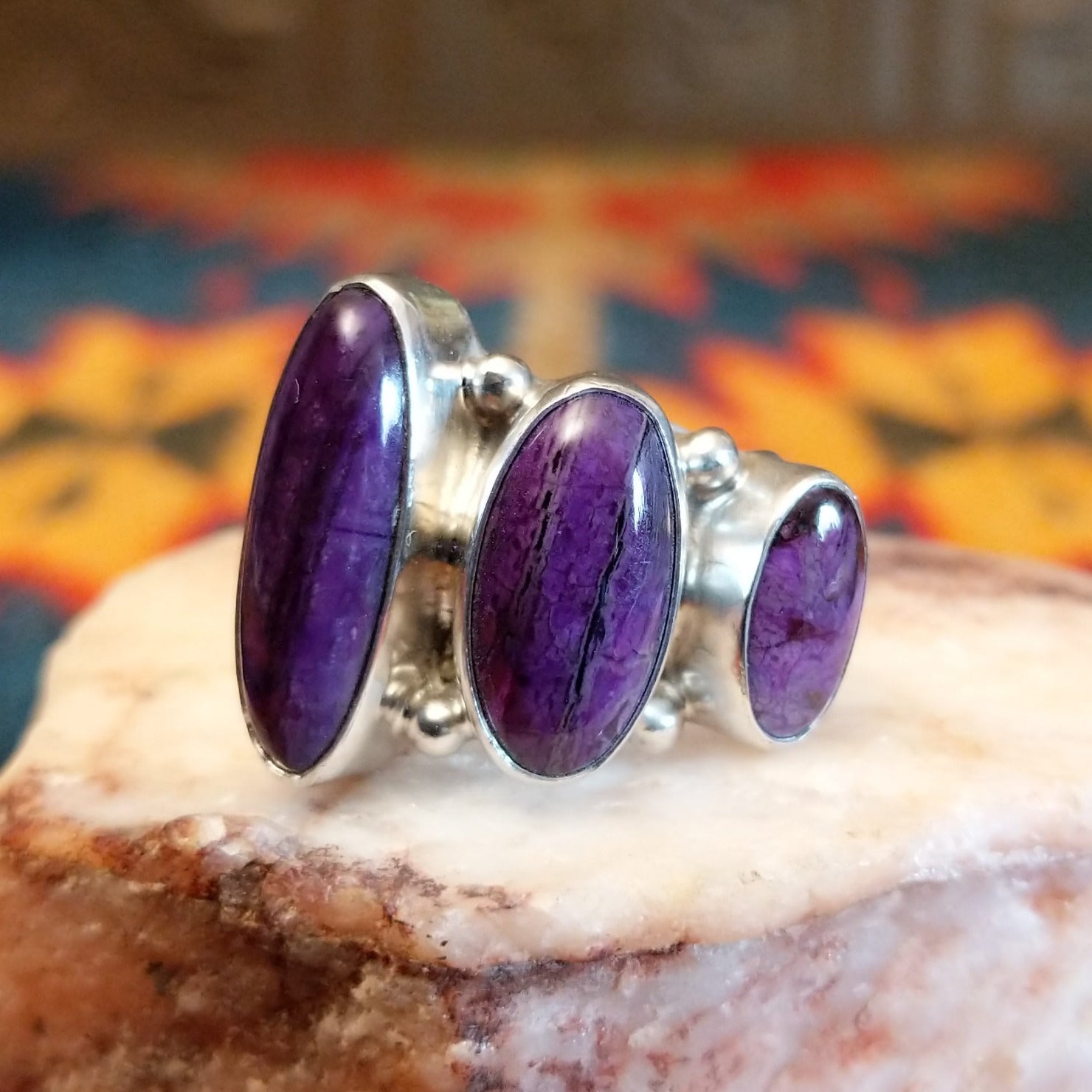 Sterling silver ring with unique bezels featuring sugilite set within.