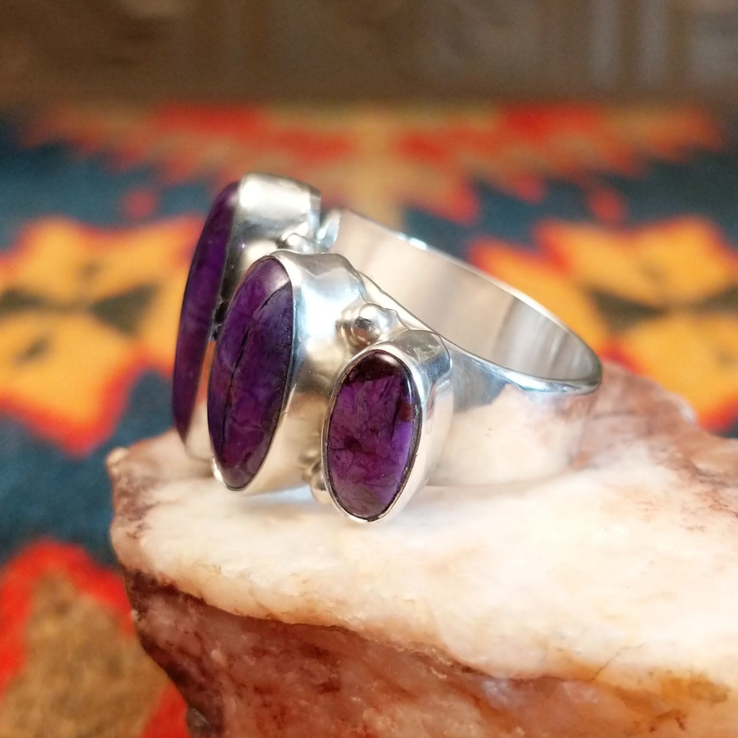 Sterling silver ring with unique bezels featuring sugilite set within.