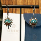 The front of the earrings feature turquoise and Lake Powell sand set in sun bezels with a lever-back closure on the earrings.