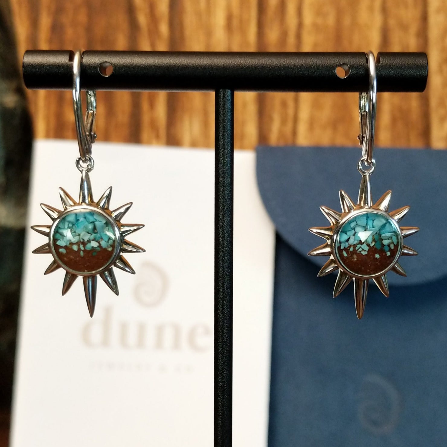 The front of the earrings feature turquoise and Lake Powell sand set in sun bezels with a lever-back closure on the earrings.