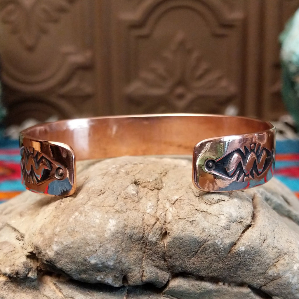 Copper and sterling silver cuff with sun stamps and polished finish.