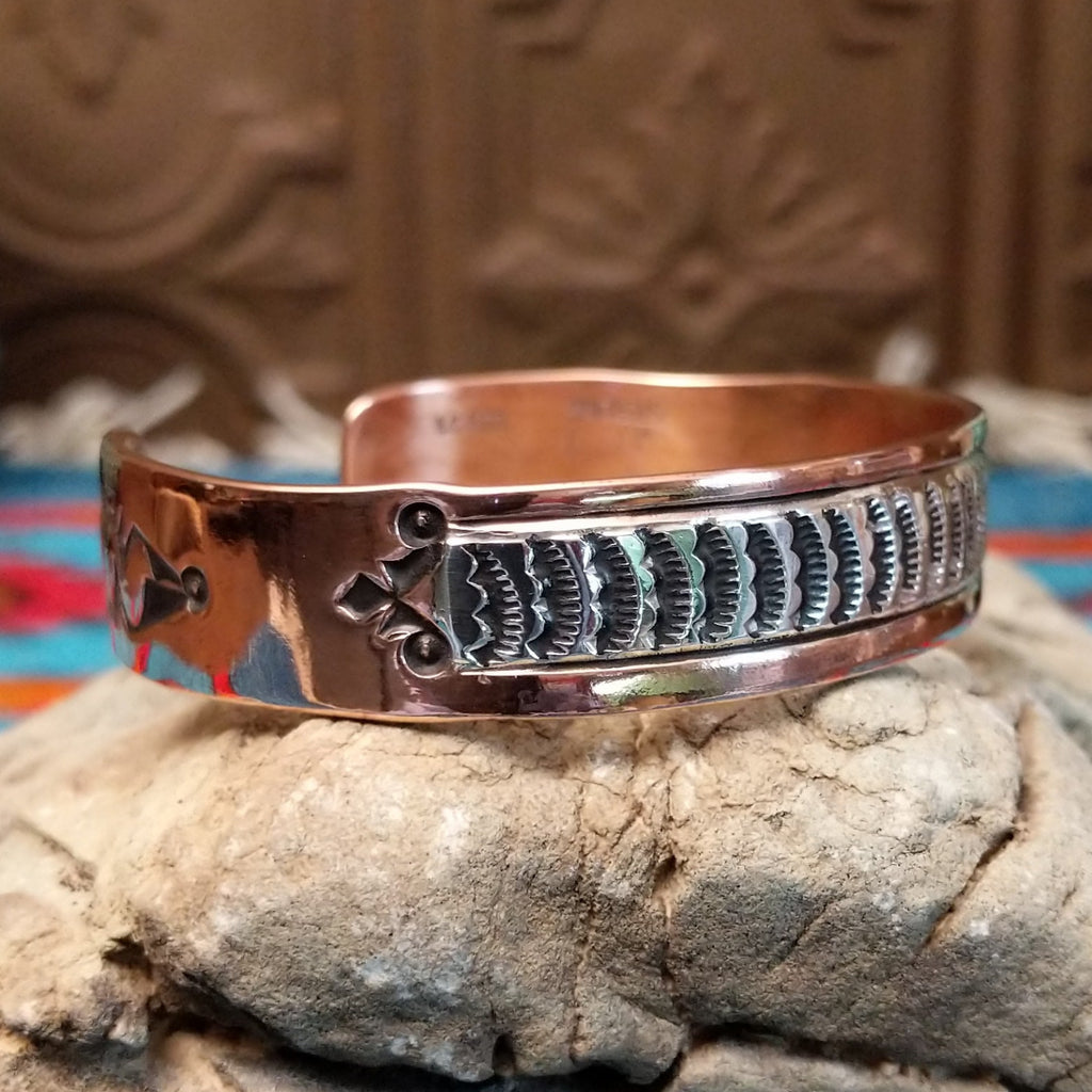 Copper and sterling silver cuff with sun stamps and polished finish.