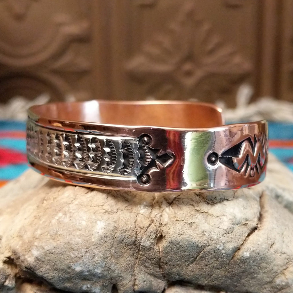 Copper and sterling silver cuff with sun stamps and polished finish.
