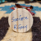 Underside of mini sunface kachina doll showing handwritten signature and label on wood base.