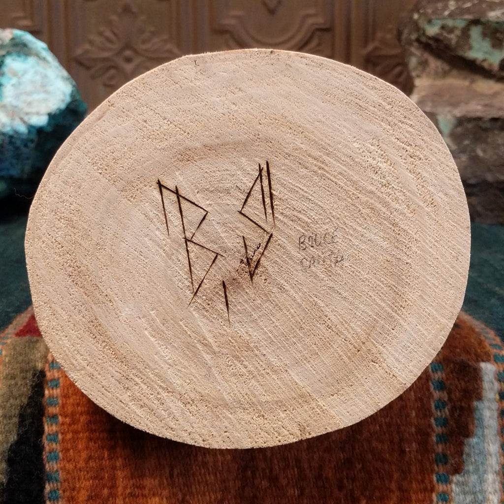 The artisan's signature is found on the base of the piece.
