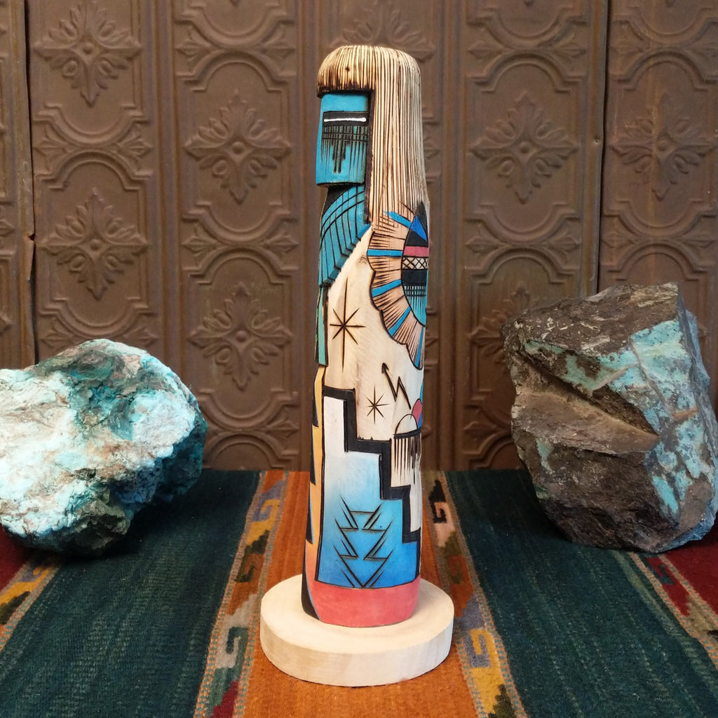 Sunface Shalako Kachina with a vibrant blue face and colorful designs all along the body.