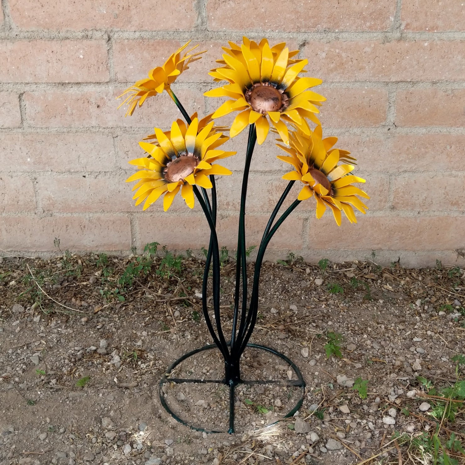 A metal sunflower bouquet with bright yellow petals and copper centers on black-green stems.