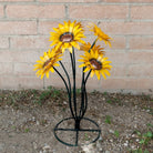 A metal sunflower bouquet with bright yellow petals and copper centers on black-green stems.