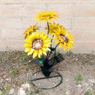 A metal sunflower bouquet with bright yellow petals and copper centers on black-green stems.