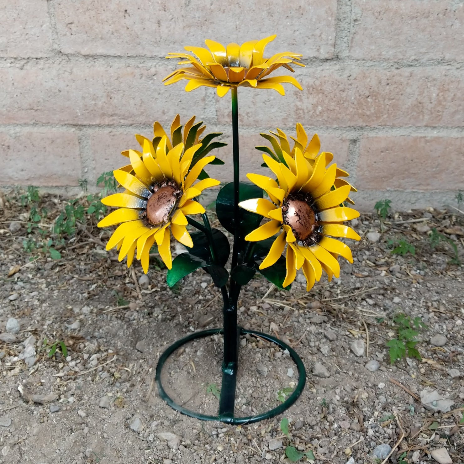 A metal sunflower bouquet with bright yellow petals and copper centers on black-green stems.