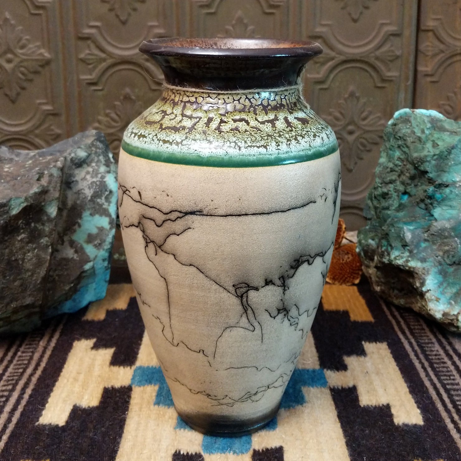 Ceramic pottery piece with horsehair fired onto the surface, and crackled moss colored glaze on the top half of the pot.
