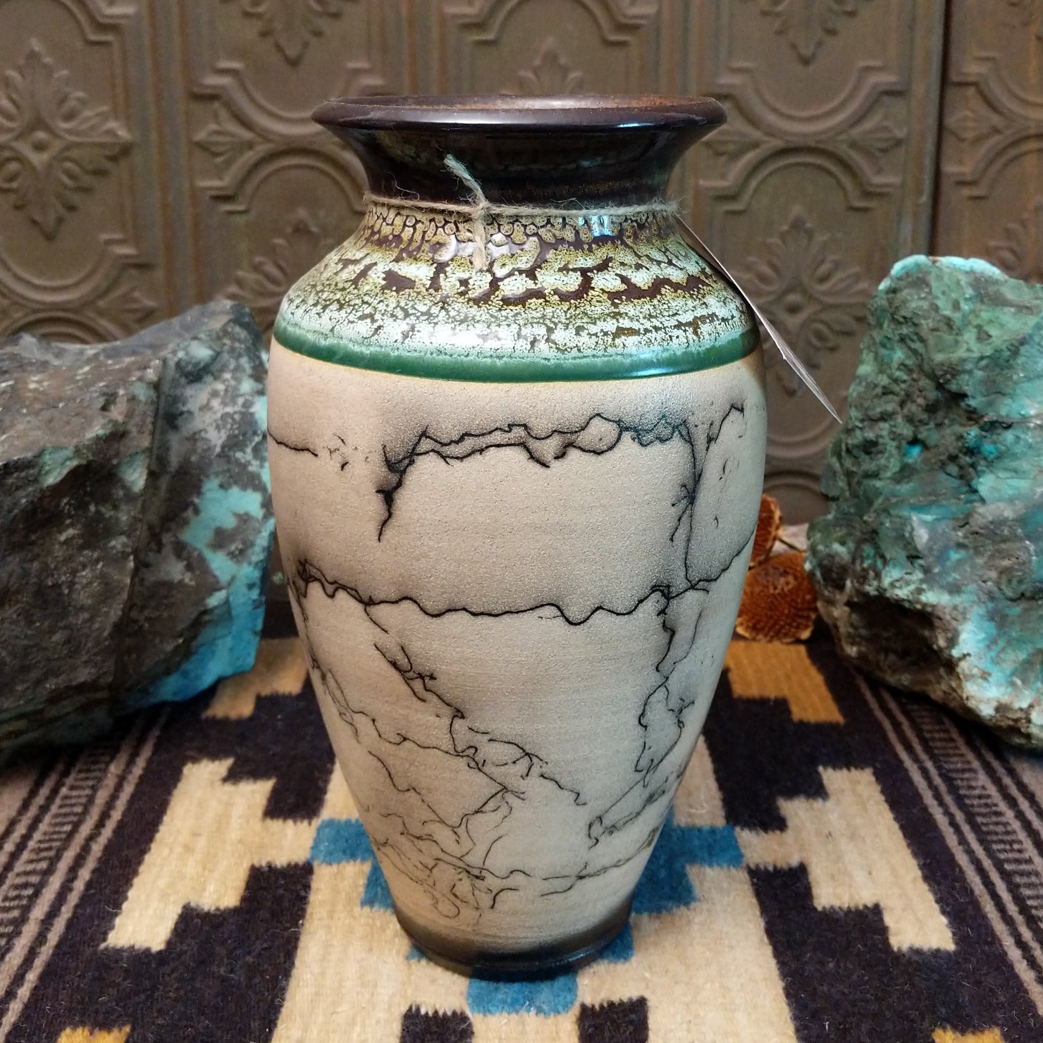 Ceramic pottery piece with horsehair fired onto the surface, and crackled moss colored glaze on the top half of the pot.