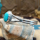 Sterling silver cuff with turquoise set in an oval bezel, framed by twisted rope and incised setting.