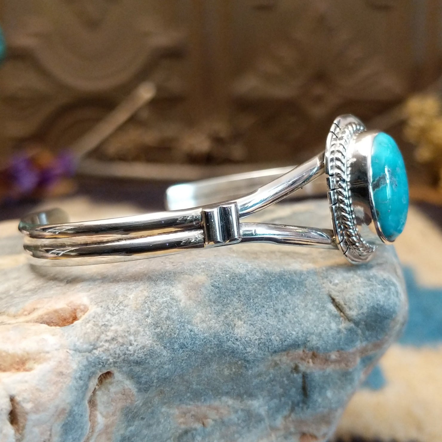 Sterling silver cuff with turquoise set in an oval bezel, framed by twisted rope and incised setting.