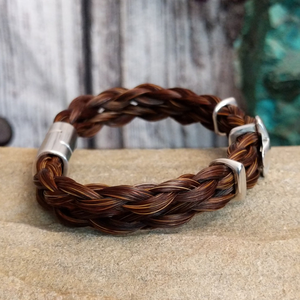 Braided brown horsehair bracelet with metal cross accent.