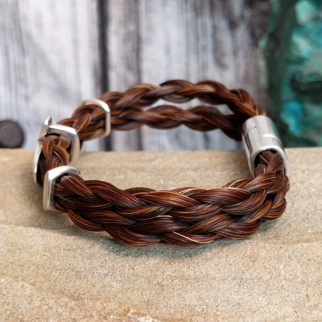 Braided brown horsehair bracelet with metal cross accent.