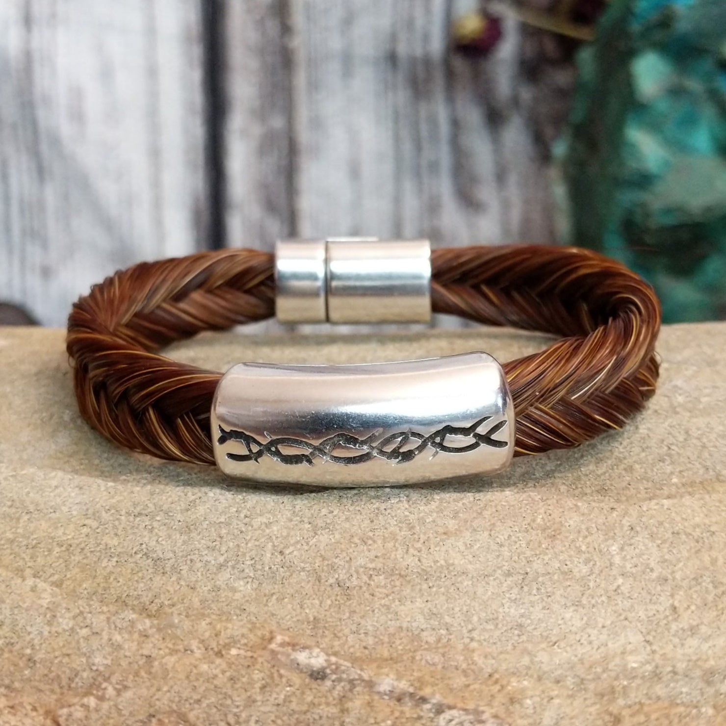 A braided brown horsehair bracelet with barbed wire detailing.