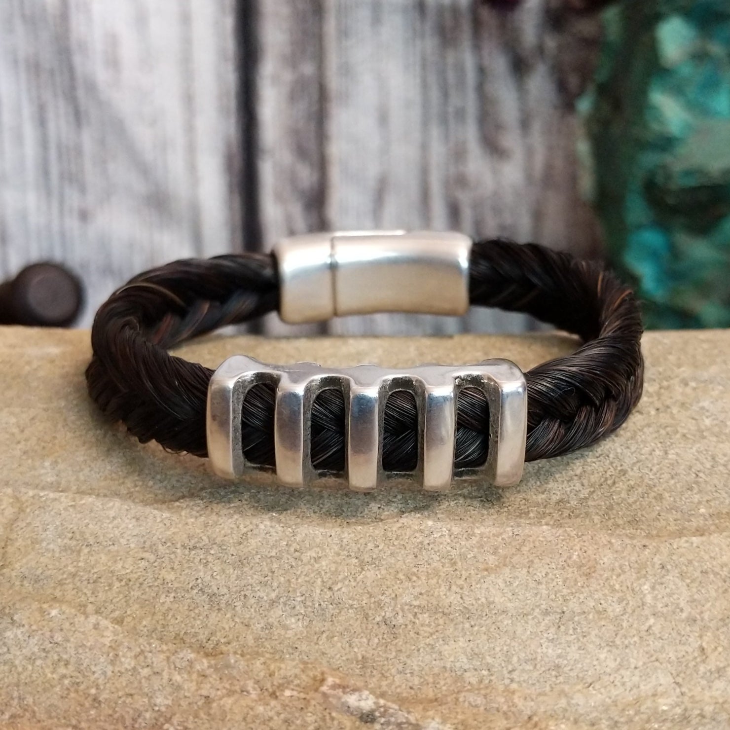 Braided dark brown horsehair bracelet with a metal grille accent and a magnetic clasp.