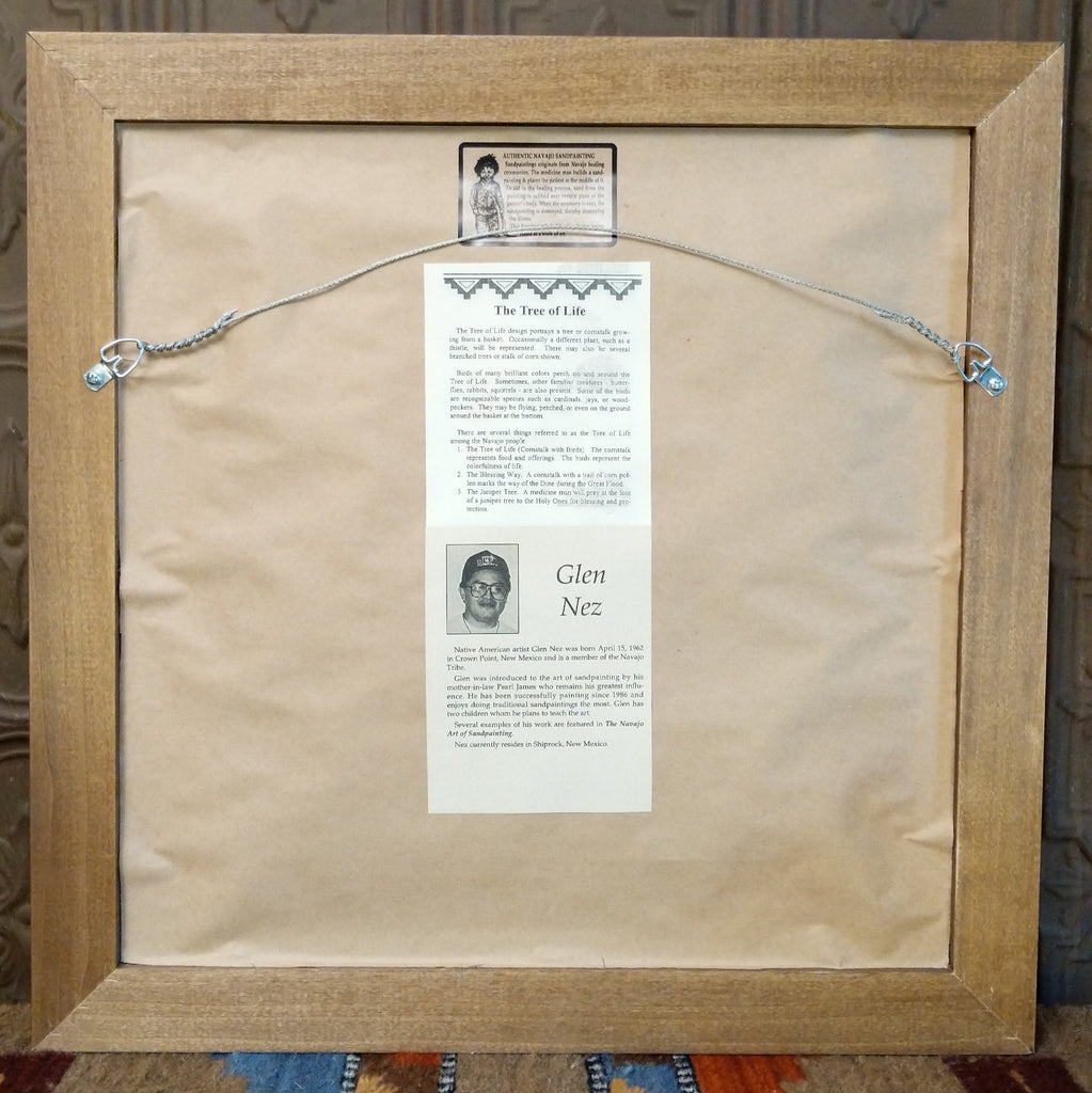 The back features a wire hook and artisan information.
