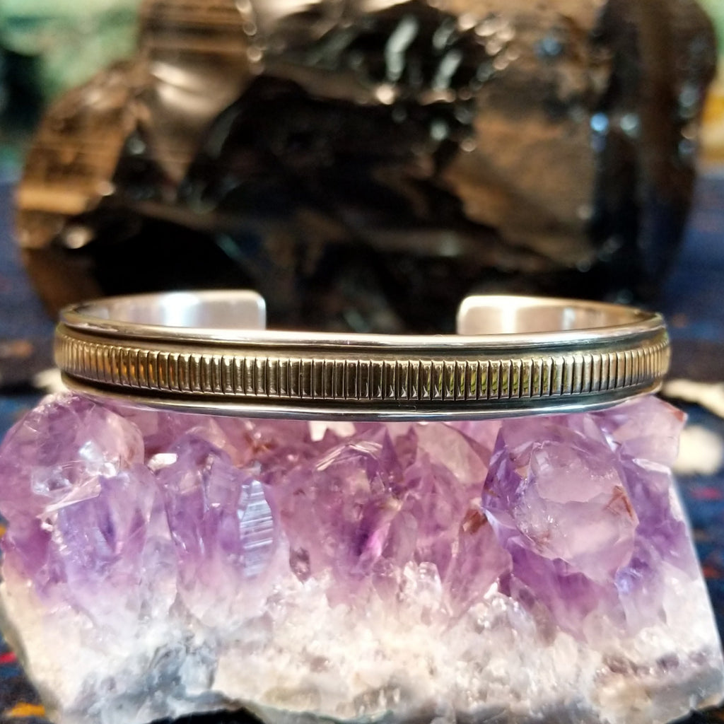 Thin sterling silver and polished gold cuff with intricate detailing.