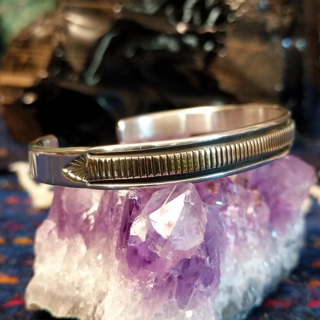 Thin sterling silver and polished gold cuff with intricate detailing.