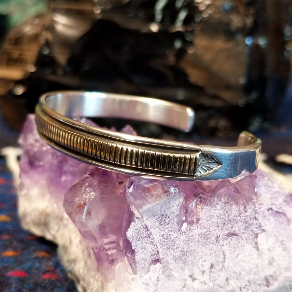 Thin sterling silver and polished gold cuff with intricate detailing.