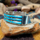 Handcrafted sterling silver three-row cuff by Sheldon Lalio featuring sleek channel inlay detailing across three parallel bands of turquoise with polished sterling silver craftsmanship; side view.