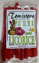 A package of Tombstone Pickled Pear Gourmet Licorice, showing the red licorice strips inside a clear plastic bag with a white label featuring floral illustrations.