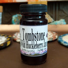 Tombstone Wild Huckleberry Jam 3 ounce bottle on a table.