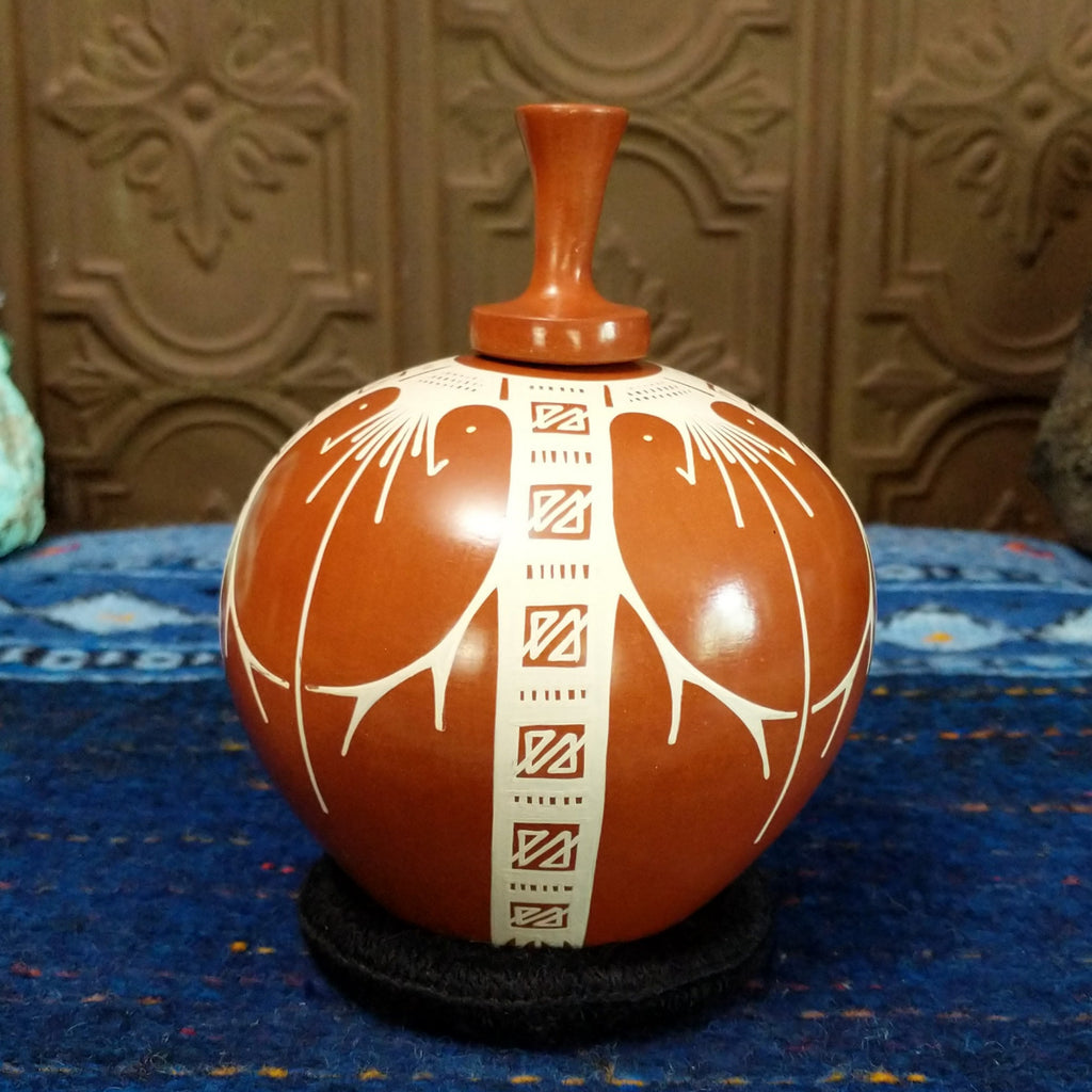 Terracotta body with white geometric designs.