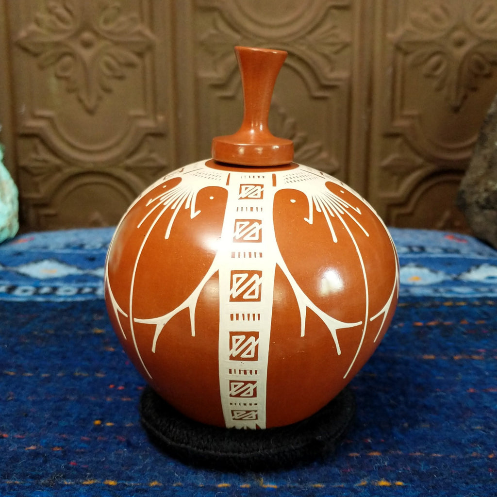 Terracotta body with white geometric designs.