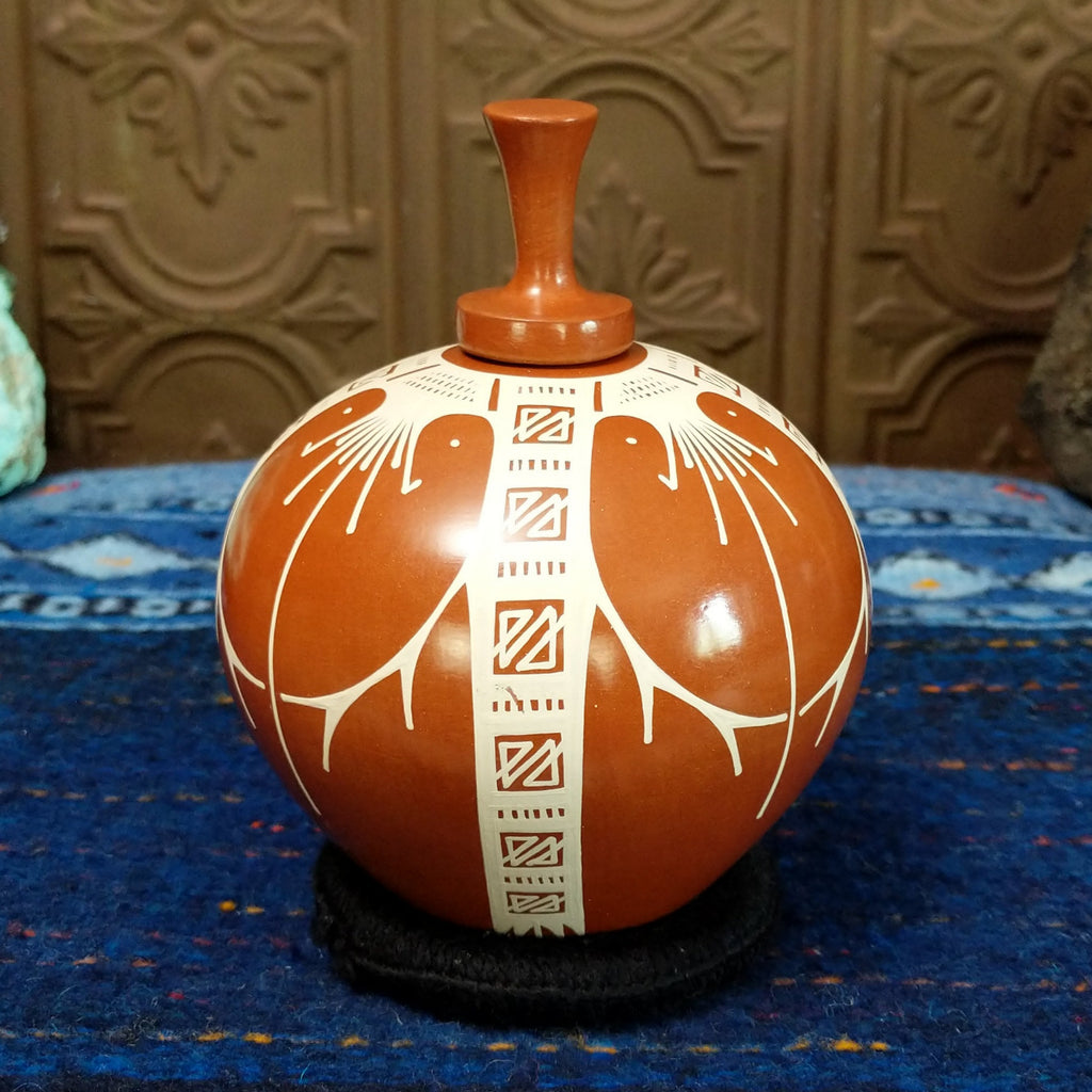 Terracotta body with white geometric designs.