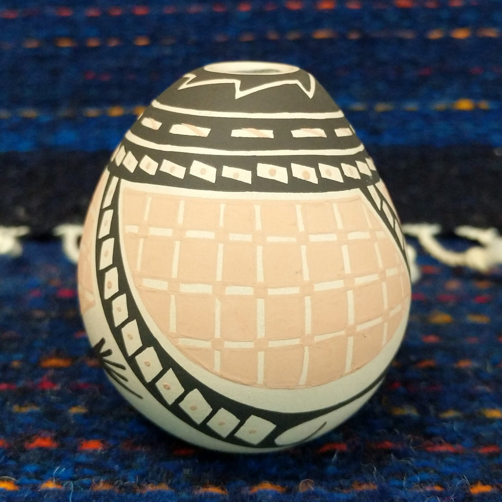 Black, white, and tan geometic patterns on the seed pot.