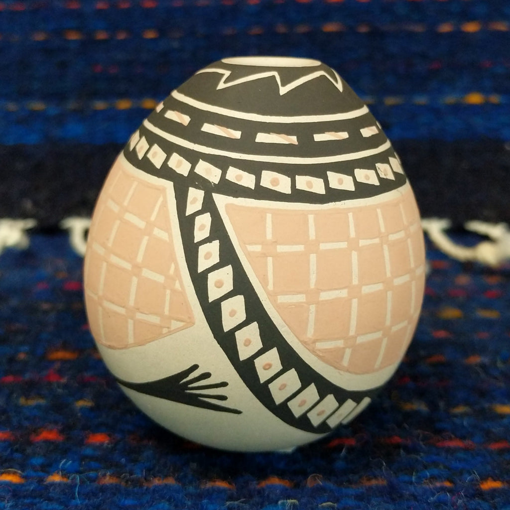 Black, white, and tan geometic patterns on the seed pot.