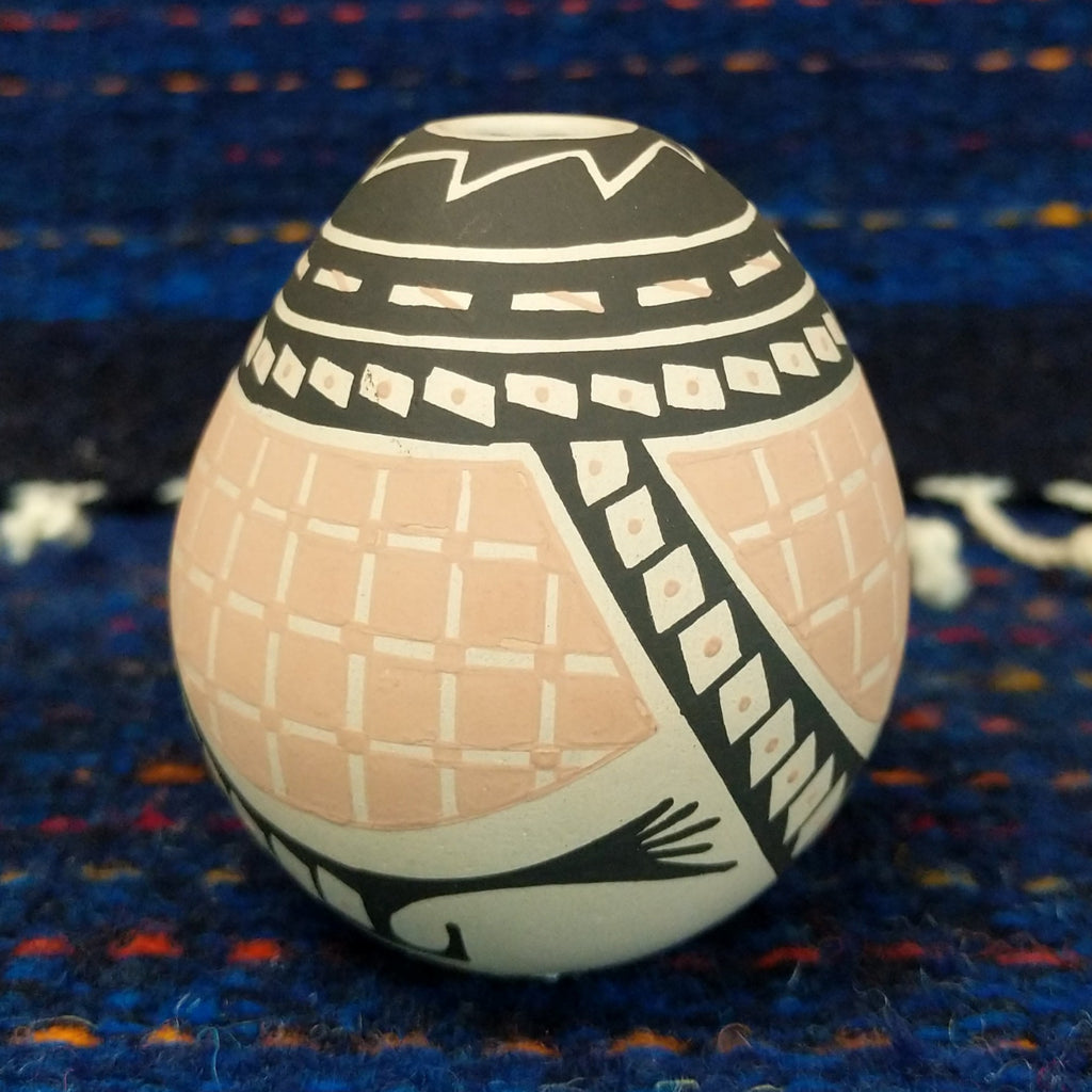 Black, white, and tan geometic patterns on the seed pot.